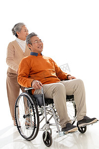 坐轮椅的人物摄影照片_老人推着坐轮椅的老伴