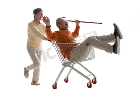 人物购物车购物摄影照片_快乐老人推着坐在购物车里的老伴