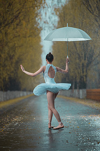 拿雨伞的美女摄影照片_拿着雨伞的青年女人跳芭蕾舞