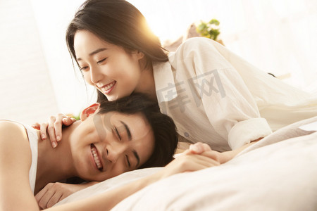 快乐的年轻情侣在床上享受甜蜜时光