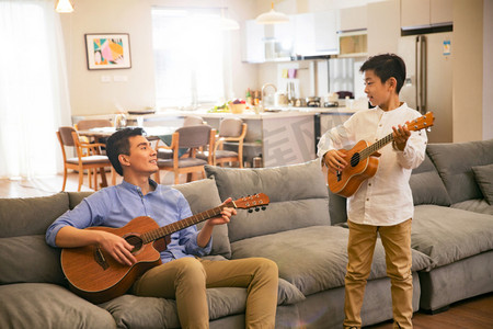 家庭室内装饰摄影照片_父亲和男孩在弹吉他