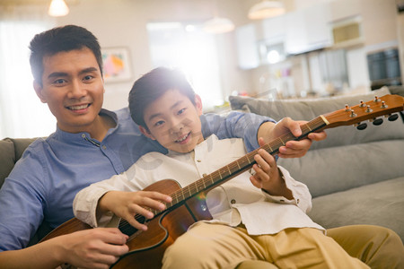 家庭教育家庭教育摄影照片_父亲和男孩在弹吉他