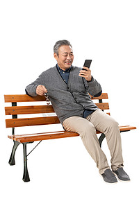 开心工作快乐生活摄影照片_快乐老人坐在长椅上看手机