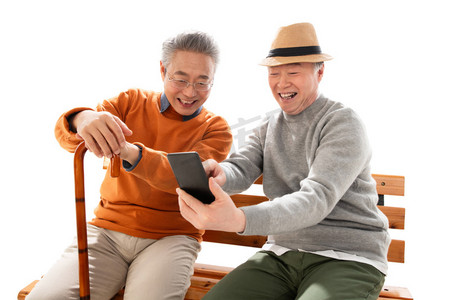 两位老年朋友坐在长椅上看手机