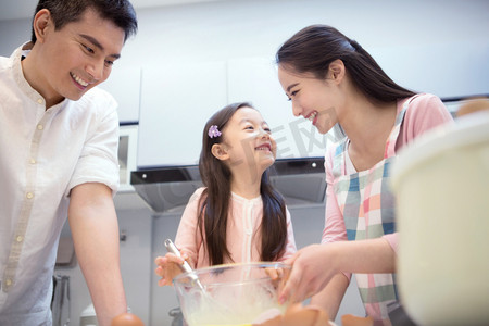 年轻亚洲家庭摄影照片_幸福家庭在厨房