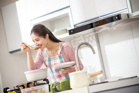 在做饭的人摄影照片_青年女人在厨房煲汤