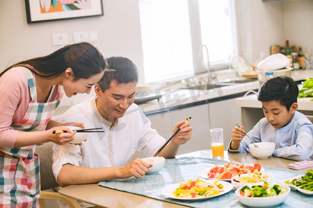 年轻亚洲家庭摄影照片_幸福家庭在吃饭