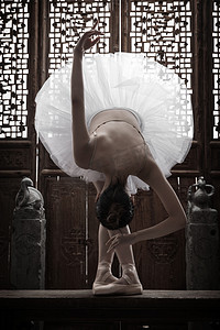 向下跳摄影照片_青年女人在中式古典门前跳芭蕾舞