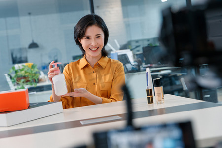 导购摄影照片_青年女人在线直播销售化妆品