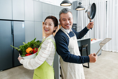 厨房欢乐摄影照片_快乐的中老夫妇在厨房做饭