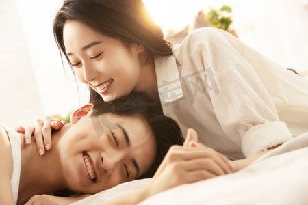 可爱情侣人物摄影照片_亲密的年轻情侣在床上享受甜蜜时光