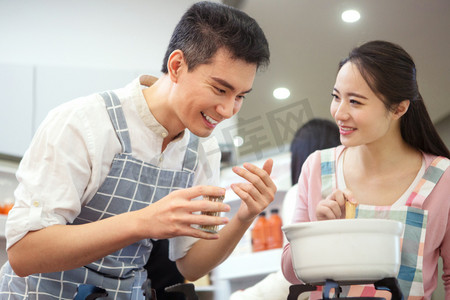 煲汤摄影照片_年轻夫妇在厨房煲汤