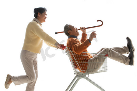 促销活动国潮摄影照片_快乐老人推着坐在购物车里的老伴
