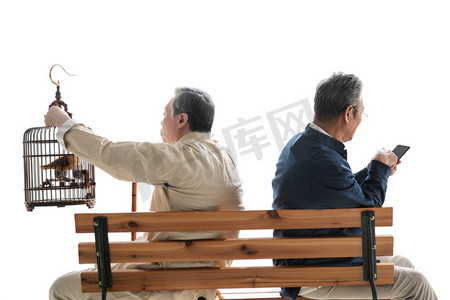 拿着鸟笼的老人和拿着手机的老人坐在长椅上