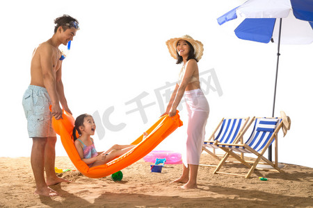 嬉戏摄影照片_幸福家庭在沙滩上玩耍