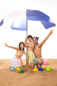 夏日游泳圈摄影照片_幸福家庭在沙滩上玩耍