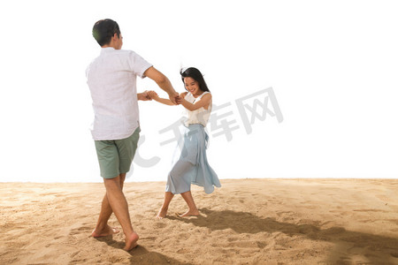 海滩多人摄影照片_年轻情侣在沙滩上玩耍