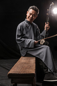 中国古典乐器摄影照片_男艺术家在拉二胡
