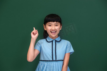 彩色裙子摄影照片_小学女生站在黑板前