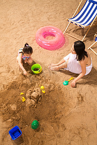 夏日游泳圈摄影照片_母亲和女儿在沙滩上玩耍