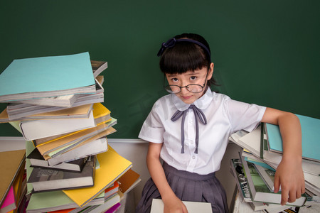 一家人读书摄影照片_坐在书堆里的小学女生