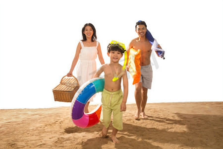 夏日游泳圈摄影照片_幸福家庭在沙滩上玩耍