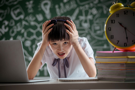 人物痛苦表情摄影照片_挫败的小学女生