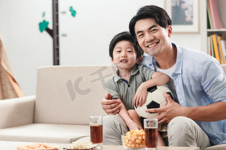 足球赛摄影照片_欢乐的父子在看足球赛