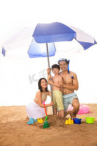 游泳圈的男孩摄影照片_幸福家庭在沙滩上玩耍