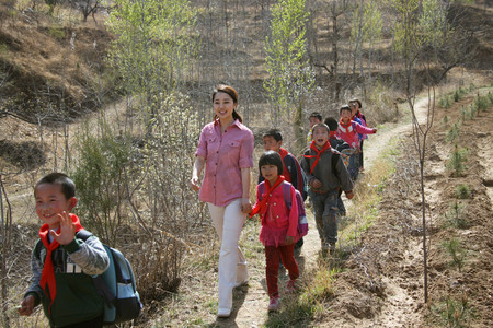 乡村老师和学生走在山路上