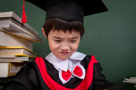 亚洲男孩摄影照片_穿着学士服的小学男生