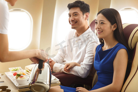安全食品摄影照片_年轻夫妇在飞机上用餐
