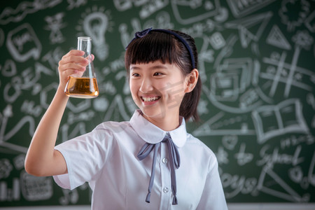 化学粉摄影照片_小学女生拿着烧杯