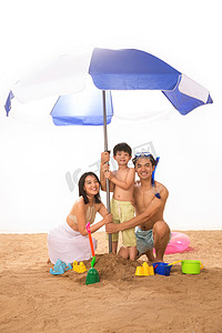 夏季沙滩游泳摄影照片_幸福家庭在沙滩上玩耍