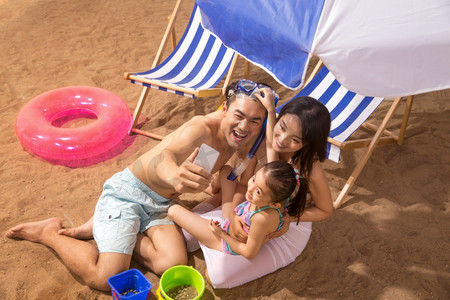 嬉戏摄影照片_幸福家庭在沙滩上玩耍