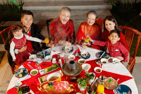 手绘61儿童节摄影照片_东方家庭在中式庭院内干杯庆祝新年