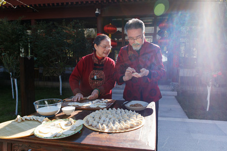 除夕团圆饭图摄影照片_幸福的老年夫妇过年包饺子