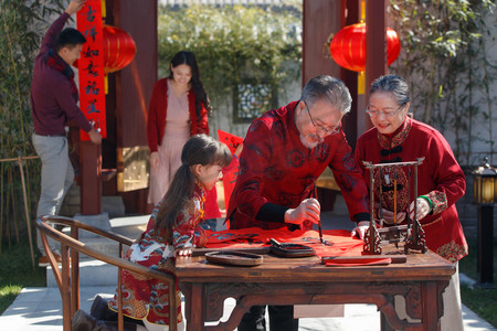 中式新年摄影照片_幸福的大家庭贴春联庆祝新年