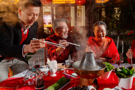 中式家装摄影照片_东方家庭在中式庭院内干杯庆祝新年