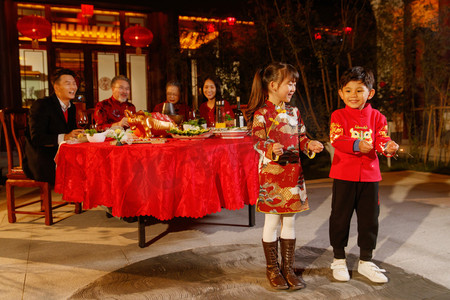 除夕到摄影照片_东方家庭在中式庭院内干杯庆祝新年