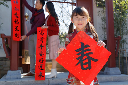 祖父母和孙女三人一起写春联