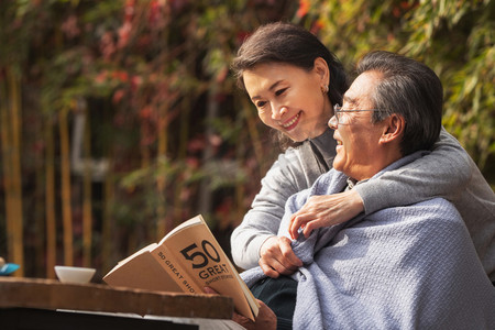 幸福的老年夫妇在户外看书