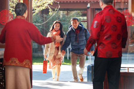 东方家庭在中式庭院内干杯庆祝新年