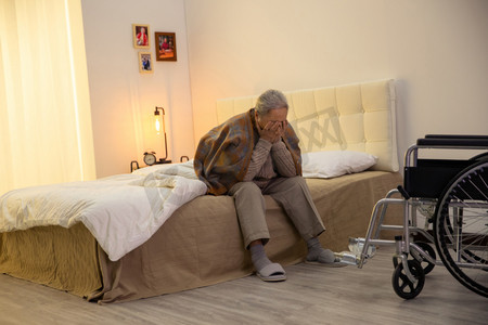 卧室摄影照片_孤独的老人坐在轮椅上