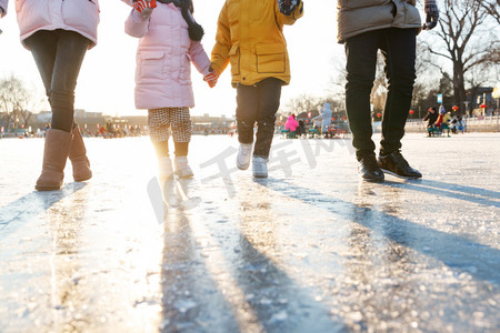 都市家庭摄影照片_快乐家庭手牵手滑冰