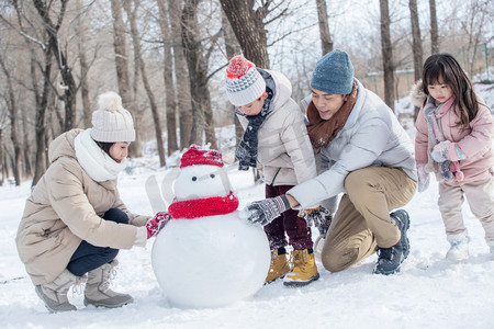 欢乐家庭在雪地里堆雪人一家三口在雪地里堆雪人一家三口在雪地里堆