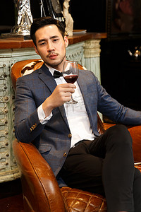 欧式风格摄影照片_青年男人拿着红葡萄酒杯