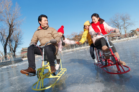冬季亲情摄影照片_快乐的一家四口在滑冰场玩耍