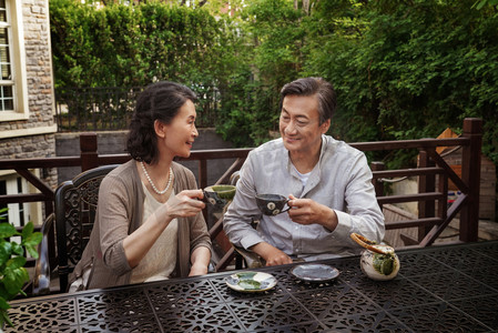 老年夫妇坐在院子里喝茶