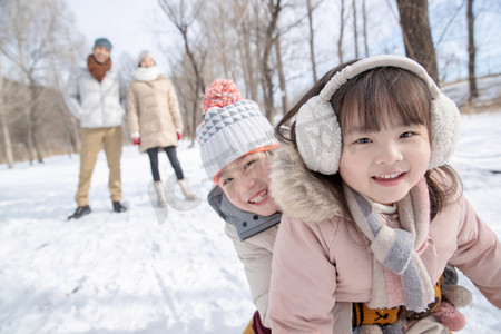 欢乐家庭在雪地上玩雪橇